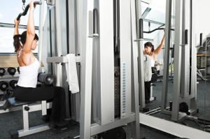 woman about to perform lat pulldowns at gym